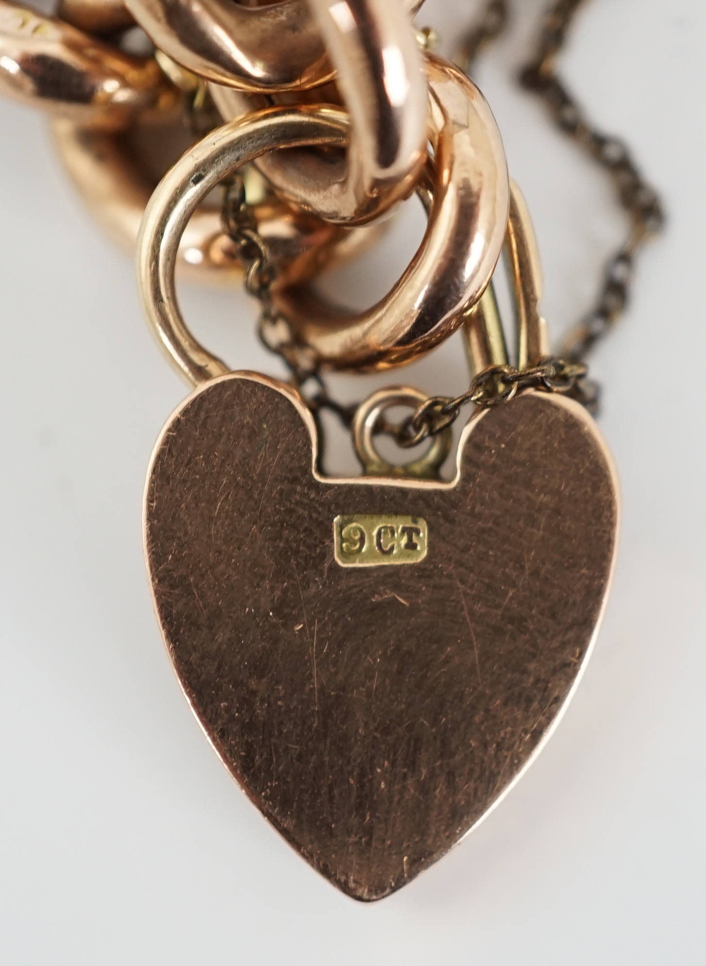 An Edwardian 9ct engraved curb link bracelet, with heart shape padlock clasp